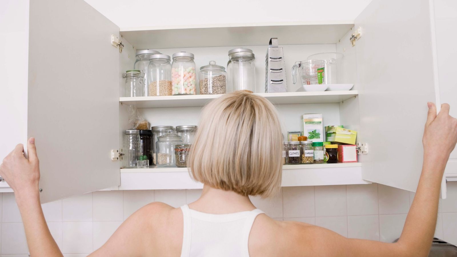 Top money saving tips check food cupboard. Woman looking in food cupboard