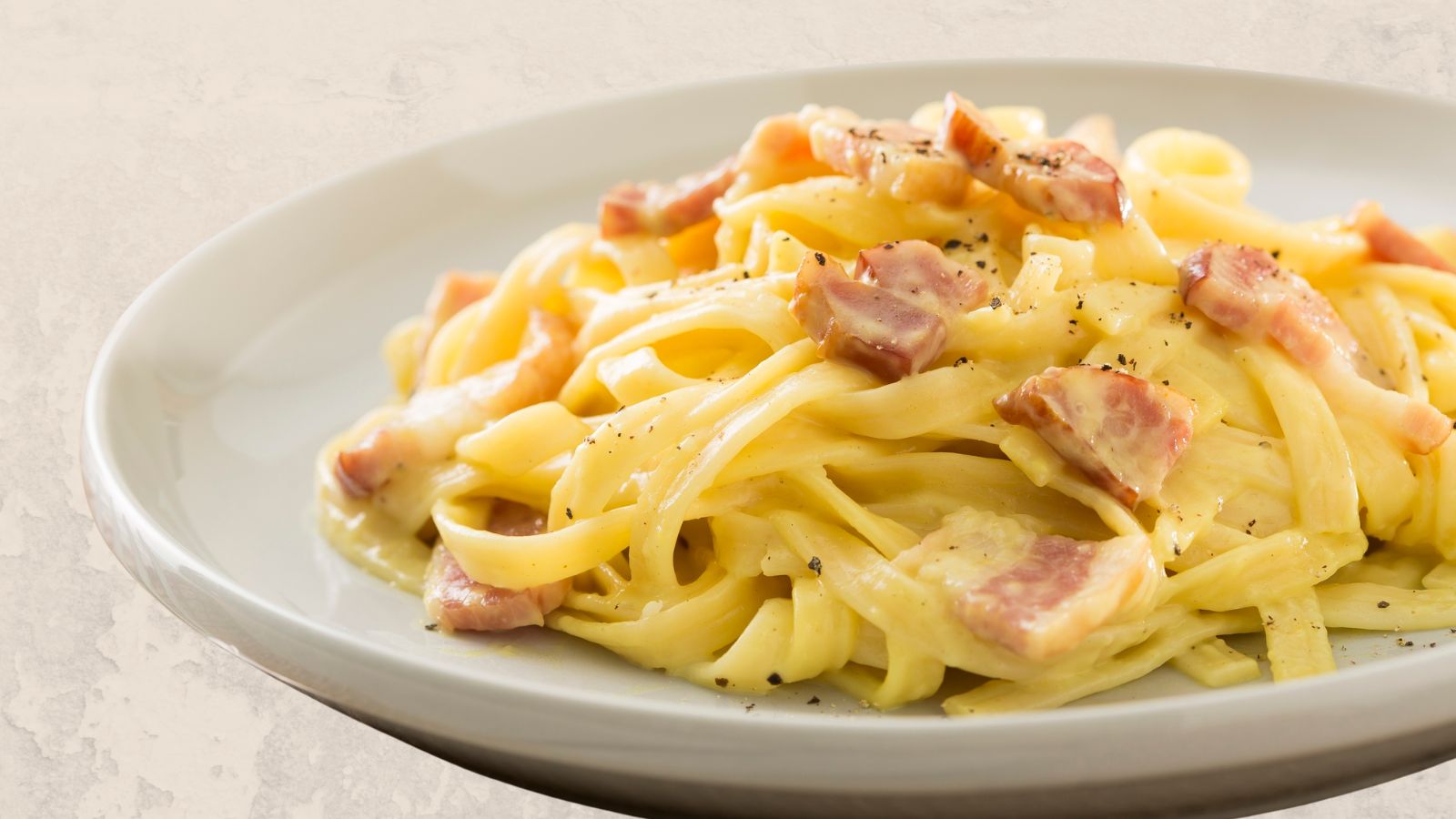 tagliatelle carbonara recipe image of a white plate containing tagliatelle carbonara