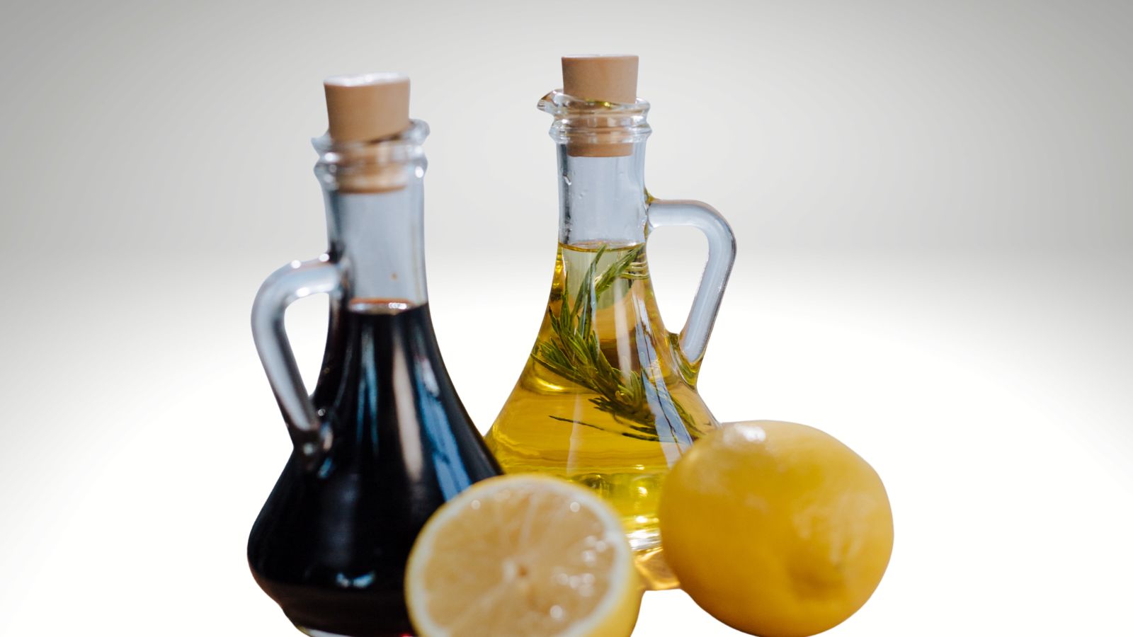 kitchen cupboard staples balsamic vinegar image of balsamic vinegar in a bottle along with lemons and lemon olive oil