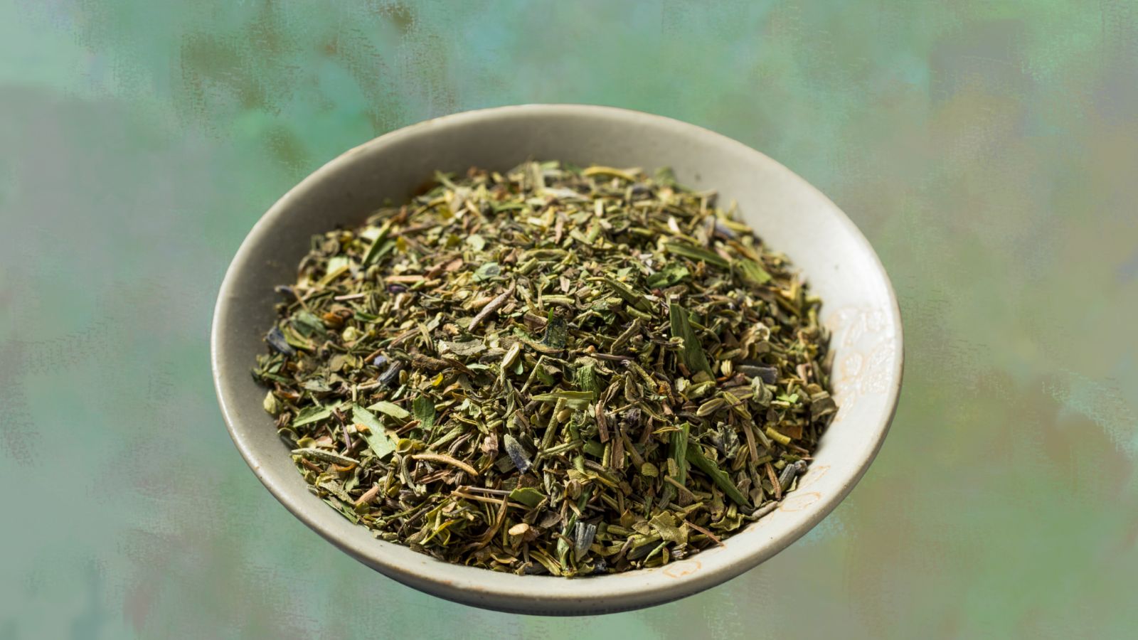image of a bowl of herbes de provence on a green background to illustrate spice rack essentials